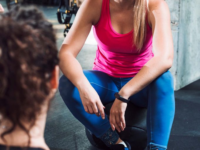 Personal trainer working with client in fitness setting