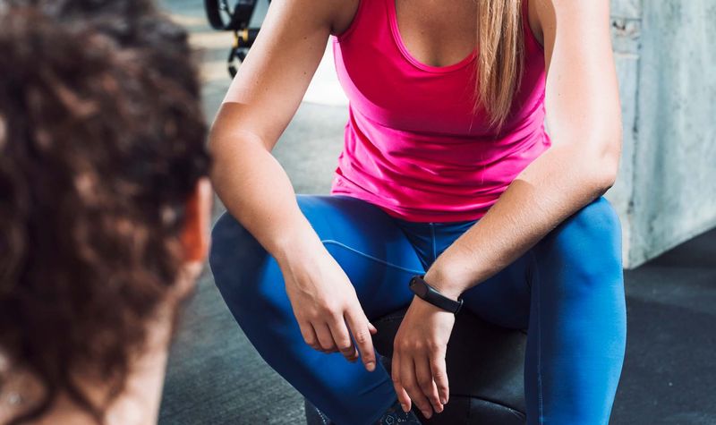 Personal trainer working with client in fitness setting